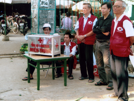 Ông Dụng (người đứng ngoài cùng bên trái) trong buổi quyên góp ủng hộ đồng bào vùng lũ miền trung tại chợ đồng Tâm.
