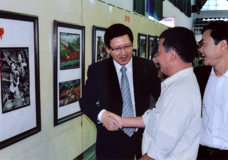 Ông Lê Xuân Thăng - Phó chủ tịch Hội Nghệ sỹ nhiếp ảnh Việt Nam chúc mừng tác giả Thanh Miền đoạt Huy chương Vàng tại liên hoan ảnh nghệ thuật các tỉnh miền núi phía Bắc lần thứ XI.