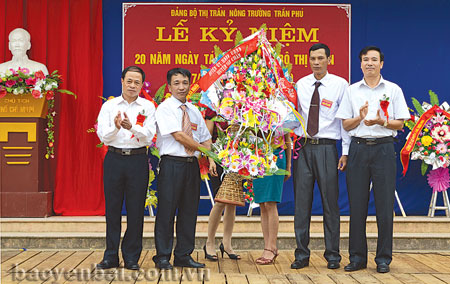 Lãnh đạo huyện Văn Chấn tặng hoa chúc mừng Đảng bộ thị trấn Nông trường Trần Phú.