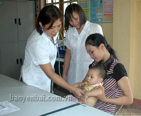 Cán bộ Trạm y tế xã Phú Thịnh (huyện Yên Bình) kiểm tra và tư vấn phương pháp chăm sóc trẻ nhỏ cho người dân.
