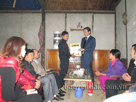 Đồng chí Dương Văn Tiến - Bí thư Huyện ủy Yên Bình tặng quà cho một hộ nghèo ở thị trấn Yên Bình.