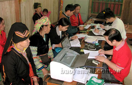 Cán bộ Ngân hàng Chính sách Xã hội huyện Văn Yên giải ngân nguồn vốn vay tới các hộ nghèo xã Mỏ Vàng. 
