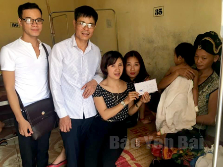 Chị Nguyễn Bảo Ngọc trao quà của các nhà hảo tâm cho cháu Bàn Thị Lưu ở thôn Khe Hóp, xã Mỏ Vàng, huyện Văn Yên.
