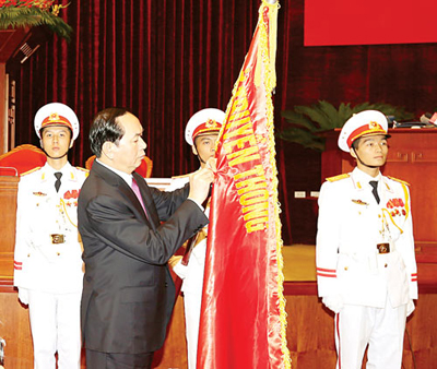 Chủ tịch nước Trần Đại Quang gắn Huân chương Độc lập hạng Nhất lên lá cờ truyền thống của Hội đồng Lý luận Trung ương.