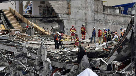 Nhân viên cứu hộ tìm kiếm nạn nhân trong đống đổ nát sau trận động đất hôm 19-9.