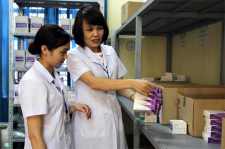 Chị Đặng Thị Thu Hương (phải) sắp xếp lại thuốc ở kho dược, Bệnh viện Tâm thần Yên Bái.