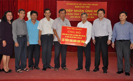 Đồng chí  Huỳnh Văn Phương -Chủ tịch Ủy ban Mặt trận Tổ quốc tỉnh Tiền Giang trao kinh phí hỗ trợ cho lãnh đạo Ủy ban Mặt trận Tổ quốc tỉnh Yên Bái.