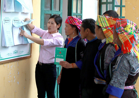 Cán bộ hướng dẫn người dân xã Púng Luông, huyện Mù Cang Chải thực hiện các thủ tục hành chính.