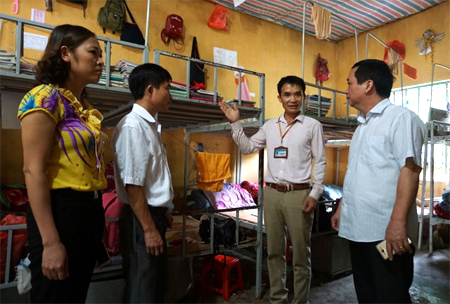 Thầy giáo Nguyễn Đức Thành (thứ 2, bên phải) giới thiệu nơi ở bán trú của học sinh nhà trường.