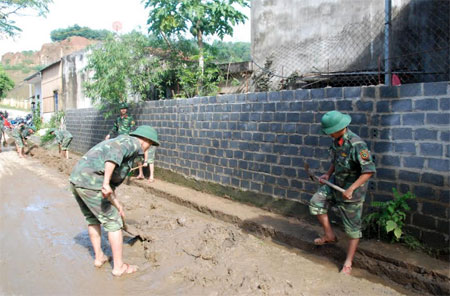 Cán bộ, chiến sỹ LLVT tỉnh giúp dân khắc phục hậu quả bão lũ 
tại huyện Văn Chấn.