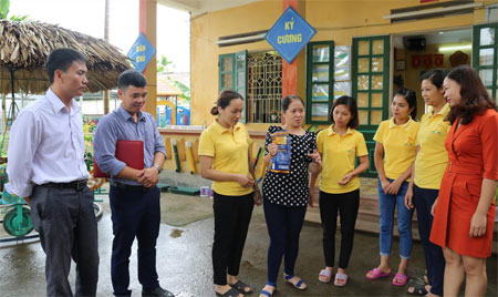 Cán bộ Trung tâm Y tế thành phố Yên Bái hướng dẫn giáo viên Trường mầm non Hướng Dương, xã Tuy Lộc, thành phố Yên Bái cách sử dụng dung dịch khử khuẩn CloraminB.