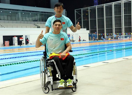 Võ Thanh Tùng (phía trước) cùng huấn luyện viên sau khi kết thúc nội dung thi đấu bơi 50m tự do.