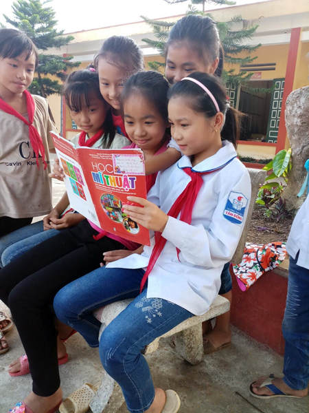 Em Trần Thị Thanh Hậu (thứ 2, bên phải) trao đổi bài với các bạn cùng lớp.