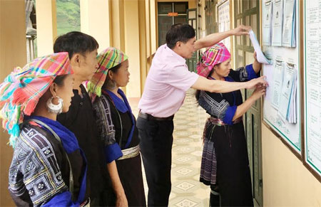 Cán bộ Phòng Giao dịch NHCSXH huyện Mù Cang Chải hướng dẫn cho người dân làm thủ tục vay vốn.