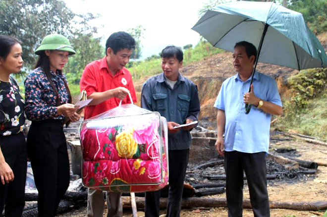 Đồng chí An Hải Nam - Phó chủ tịch UBND huyện (ngoài cùng bên phải) trao tiền hỗ trợ cho gia đình bị hỏa hoạn xã Minh Chuẩn.