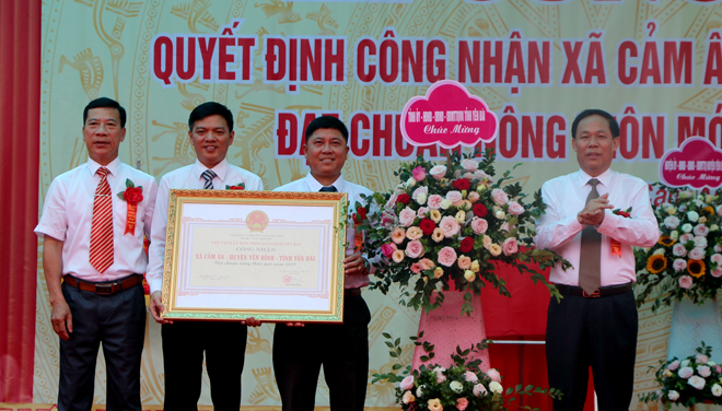 Phó Chủ tịch UBND tỉnh Nguyễn Văn Khánh trao Bằng công nhận và tặng hoa chúc mừng xã Cảm Ân đạt chuẩn nông thôn mới.