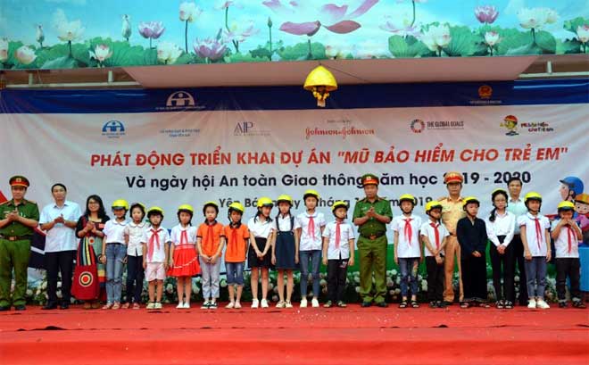 Các đồng chí lãnh đạo Ban ATGT tỉnh và Quỹ AIP trao tặng mũ bảo hiểm cho các em học sinh.