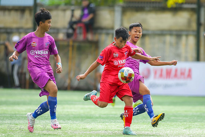 Pha tranh bóng giữa các cầu thủ U13 Hà Nội (áo đỏ) và U13 T&T VSH.