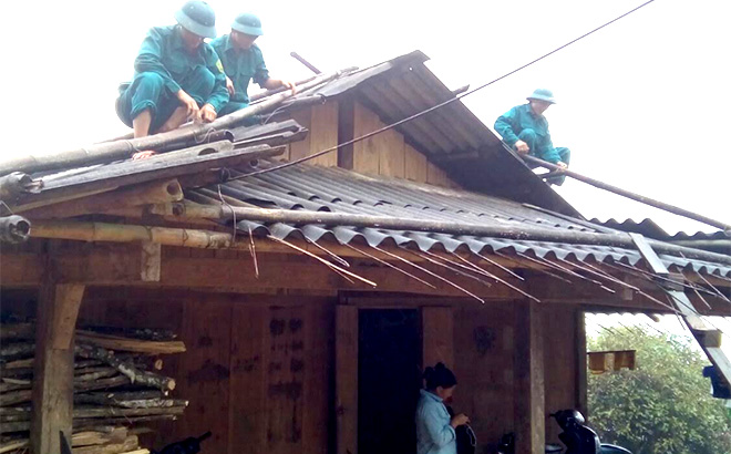 Cán bộ, chiến sĩ lực lượng vũ trang huyện Trạm Tấu giúp dân tu sửa nhà.