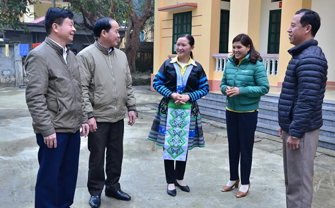Chị Sùng Thị Xía (giữa) trao đổi công tác phòng chống dịch Covid-19 với cán bộ y tế huyện và lãnh đạo xã Suối Bu.