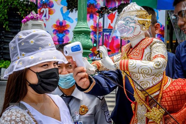 Đo thân nhiệt cho khách thăm quan phòng lây nhiễm COVID-19 tại một ngôi đền ở Bangkok, Thái Lan.