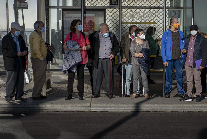 Người dân đeo khẩu trang đợi xe buýt tại thành phố Barcelona (Tây Ban Nha).