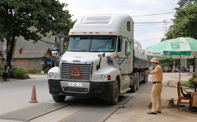 Lực lượng cảnh sát giao thông cân kiểm tra tải trọng phương tiện tại Km 14, thị trấn Yên Bình, huyện Yên Bình.