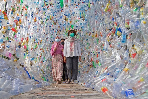 Người dân đi qua một đường hầm được tạo ra bằng các chai nhựa.