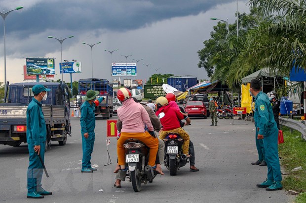 Hướng dẫn người dân đi xe máy về quê tại chốt kiểm soát của TP Cần Thơ trên Quốc lộ 1A chiều 1/10.