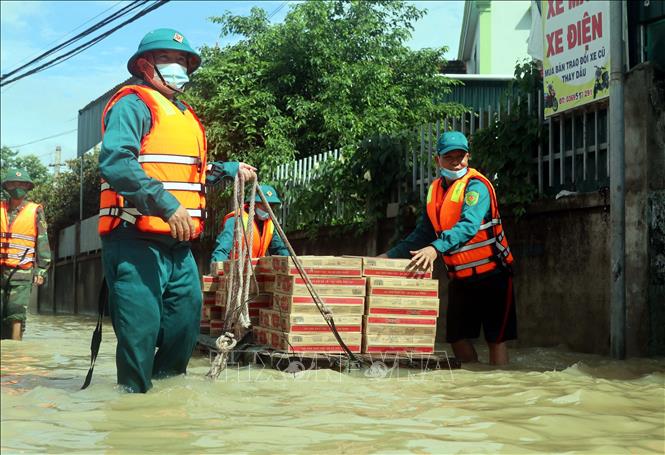 Lực lượng chức năng vận chuyển nhu yếu phẩm hỗ trợ các hộ dân bị ngập nước tại xã Quỳnh Hồng, huyện Quỳnh Lưu, Nghệ An, ngày 27/9/2021.