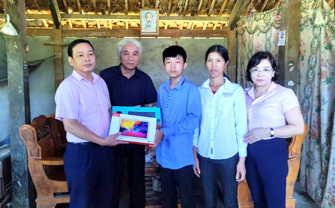 Ông Nguyễn Văn Bằng trao máy tính bảng cho cháu Nguyễn Tiến Mạnh, bản Chao, xã Việt Hồng, huyện Trấn Yên.