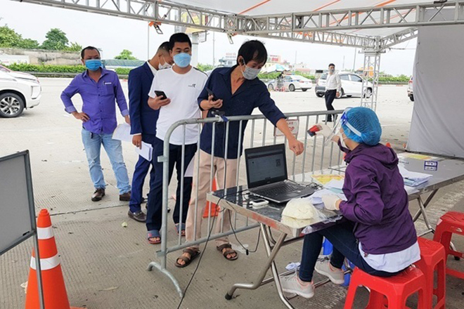 Người dân xếp hàng chờ kiểm tra giấy tờ để qua chốt ở Hà Nội