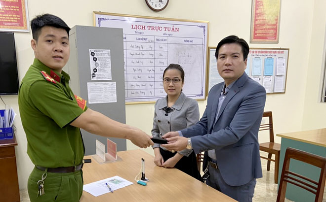 Vợ chồng anh Phan Thanh Hải và chị Nguyễn Thị Quỳnh giao nộp chiếc ví vừa nhặt được cho Công an phường Đồng Tâm, thành phố Yên Bái.