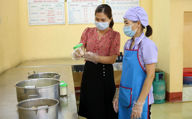 Cán bộ quản lý Trường Mầm non Yên Phú, huyện Văn Yên kiểm tra, lấy mẫu lưu thực phẩm trước khi chia suất ăn cho học sinh.