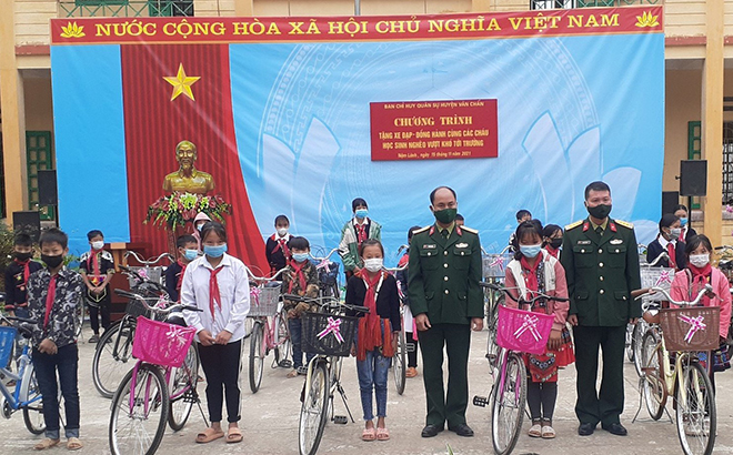 Các đồng chí lãnh đạo Ban Chỉ huy Quân sự huyện Văn Chấn trao tặng xe đạp cho các cháu học sinh nghèo vượt khó của huyện.