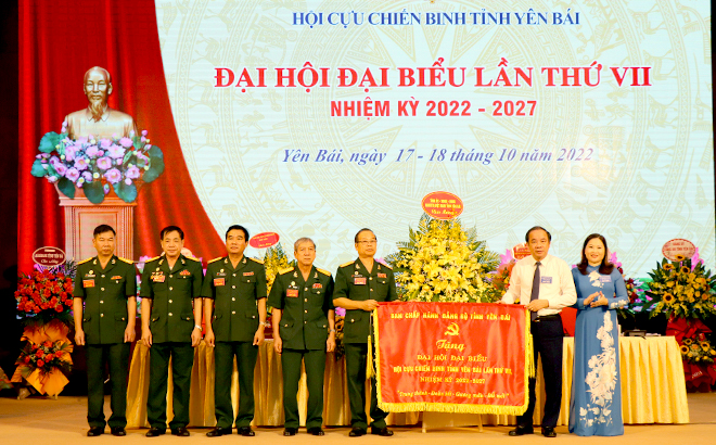 Standing Deputy Secretary of the provincial Party Committee Ta Van Long and Vice Chairwoman of the provincial People's Committee Vu Thi Hien Hanh, on behalf of the provincial leaders, present a flag bearing the words 