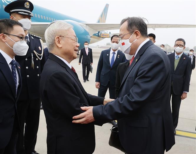 Head of the International Liaison Commission of the Central Committee of the Communist Party of China Liu Jianchao (R) welcomes Party General Secretary Nguyen Phu Trong at the Beijing International Airport on October 30