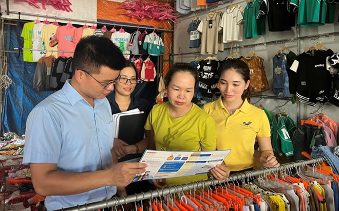 BHXH huyện Trấn Yên phối hợp tổ chức dịch vụ thu Bưu điện ra quân tuyên truyền, vận động tiểu thương chợ Cổ Phúc tham gia BHXH tự nguyện.