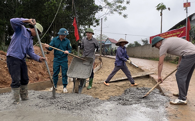 Bí thư Huyện ủy Yên Bình - An Hoàng Linh (đứng giữa) tham gia làm đường giao thông nông thôn cùng người dân.