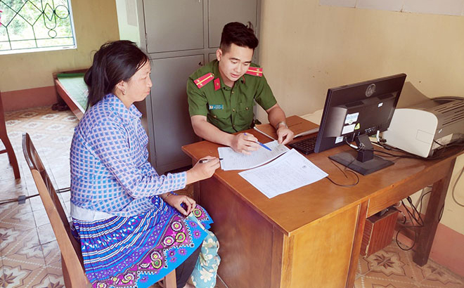 Công an huyện Mù Cang Chải hướng dẫn người dân làm thủ tục cấp Chứng minh nhân dân. (Ảnh minh họa)