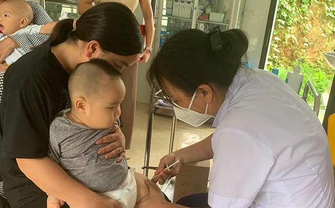 Cán bộ Trạm Y tế xã Tân Đồng, huyện Trấn Yên tiêm phòng cho trẻ.