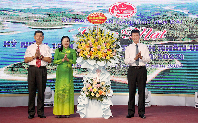Chairman of the provincial People's Committee Tran Huy Tuan offers flowers to businesses and entrepreneurs.
