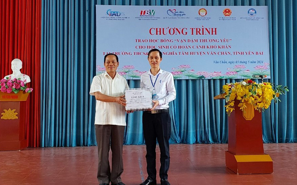 Đồng chí Triệu Tiến Thịnh - Chủ tịch Hội Khuyến học tỉnh trao biểu trưng tặng 100 cuốn sách cho Thư viện Trường THCS&THPT Nghĩa Tâm, huyện Văn Chấn.