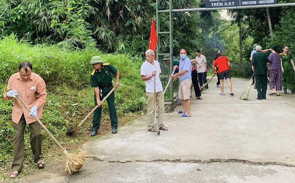 Hội viên cựu chiến binh thị trấn Yên Bình tham gia quét dọn, vệ sinh môi trường.