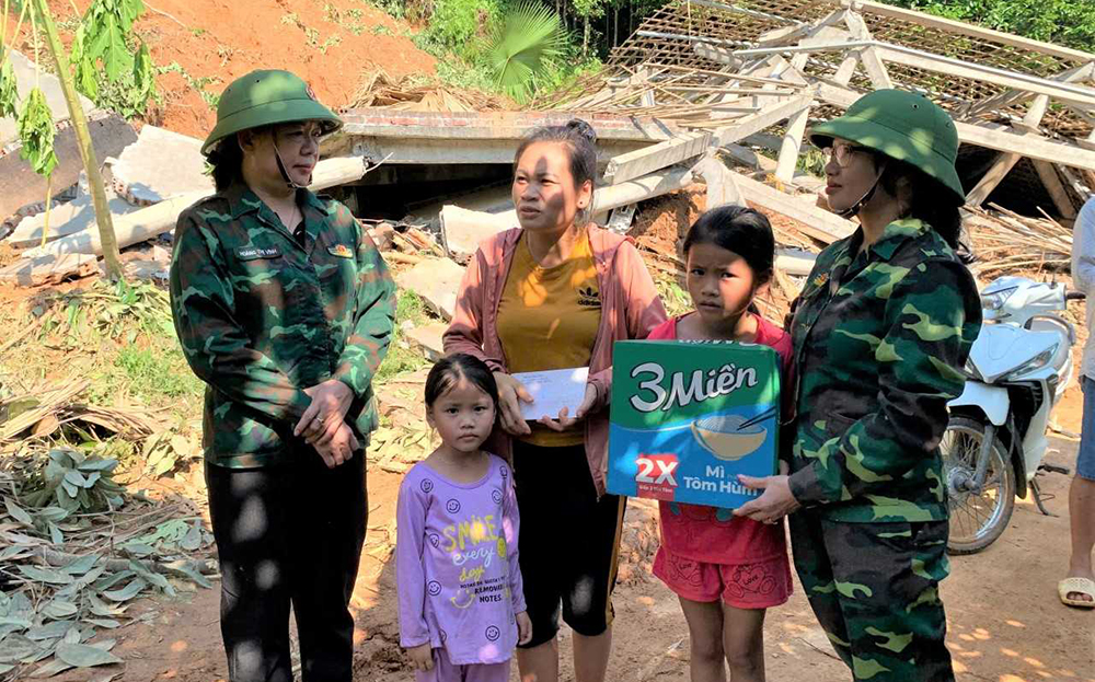 Đồng chí Hoàng Thị Vĩnh- Trưởng ban Dân vận Tỉnh ủy (trái) trao hỗ trợ cho hộ dân bị sập nhà do bão số 3