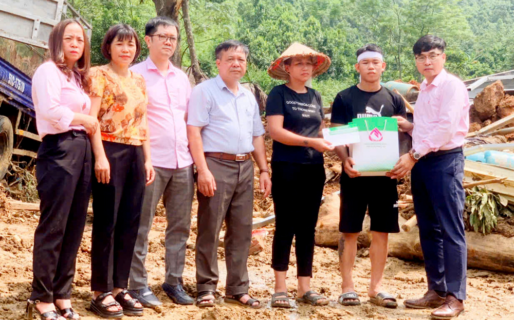 Lãnh đạo Phòng Giao dịch Ngân hàng Chính sách xã hội huyện Văn Yên trao hỗ trợ cho các hộ gia đình bị ảnh hưởng thiên tai.