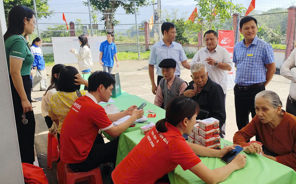 Nhân viên Viettel Yên Bái hỗ trợ người dân tổ dân phố số 6, phường Cầu Thia cài đặt và sử dụng các ứng dụng trên điện thoại thông minh.