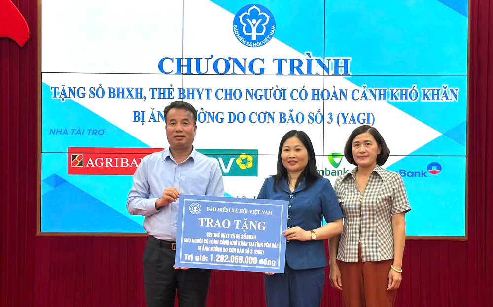 Đồng chí Nguyễn Thế Mạnh - Bí thư Ban Cán sự Đảng, Tổng Giám đốc BHXH Việt Nam trao biểu trưng 69 sổ BHXH và 820 thẻ BHYT cho tỉnh Yên Bái.