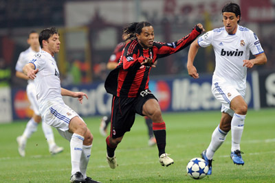 Ronaldinho (áo sọc đỏ) bế tắc trong vòng vây của các cầu thủ Real Madrid.