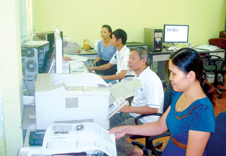 Các kỹ thuật viên thực hiện chế bản báo trên máy tính.